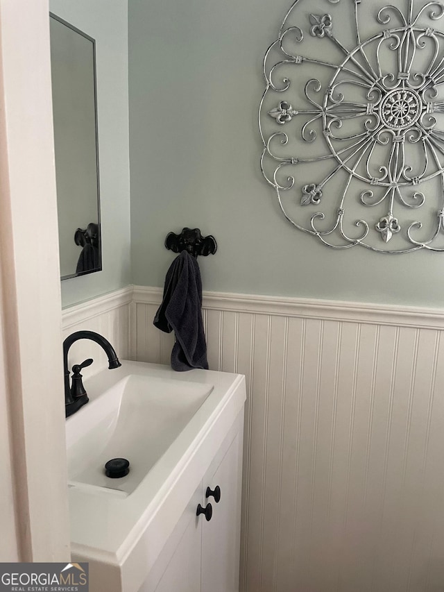 bathroom with a wainscoted wall and vanity