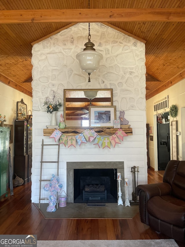 unfurnished living room featuring lofted ceiling with beams, wood ceiling, wood finished floors, and a large fireplace