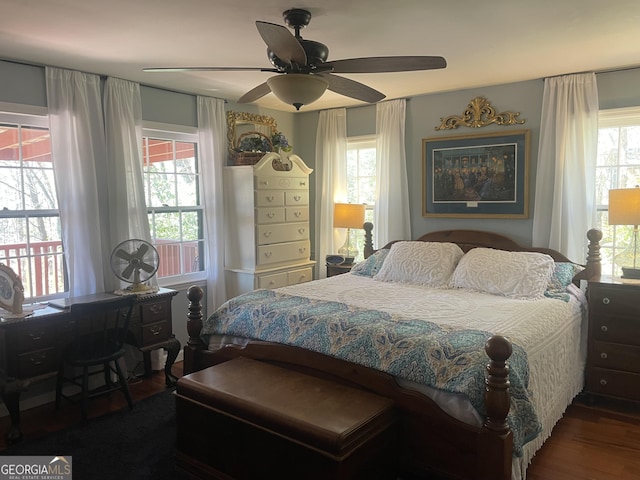 bedroom with multiple windows, ceiling fan, and wood finished floors