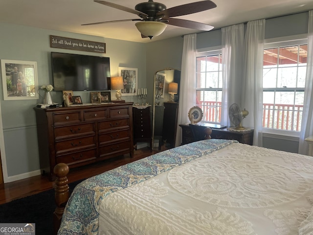 bedroom featuring a ceiling fan, wood finished floors, and baseboards