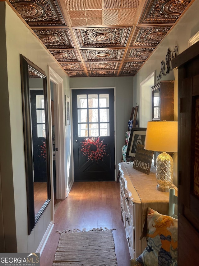 doorway to outside with wood-type flooring and an ornate ceiling