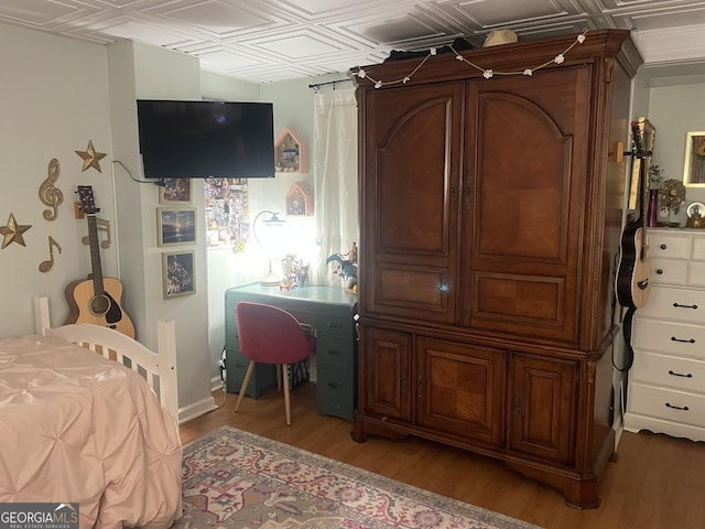 bedroom featuring light wood-type flooring and an ornate ceiling