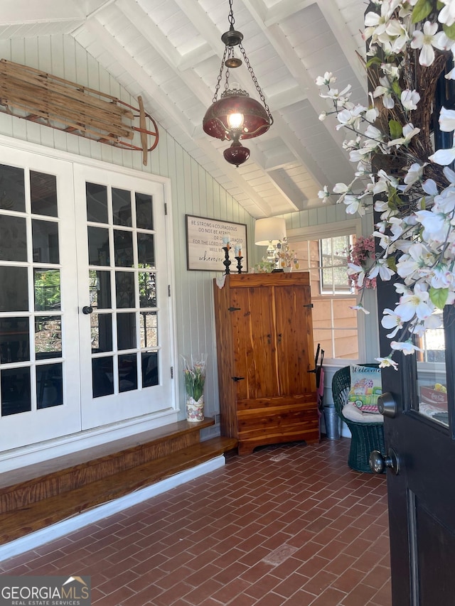 unfurnished sunroom with lofted ceiling with beams and french doors