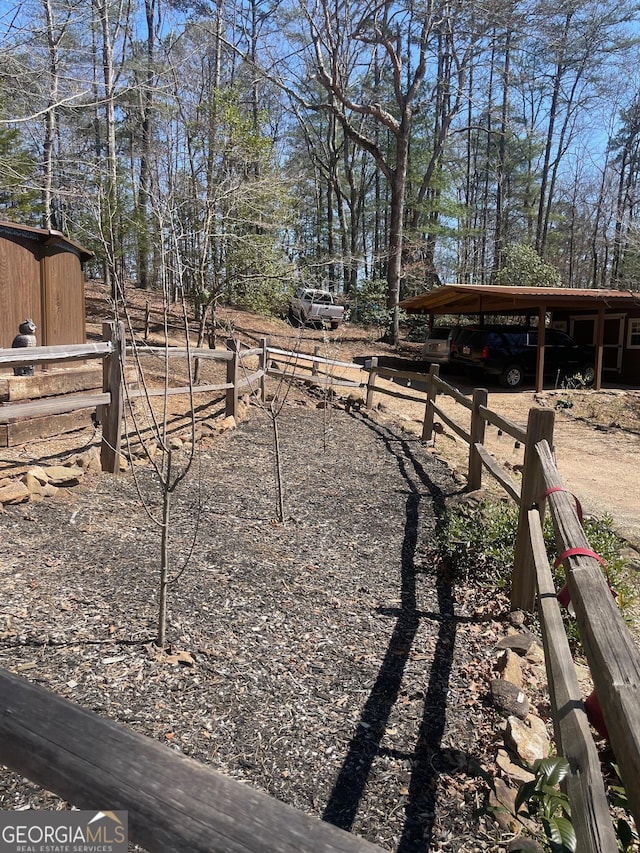 view of yard with an outbuilding, a carport, and fence