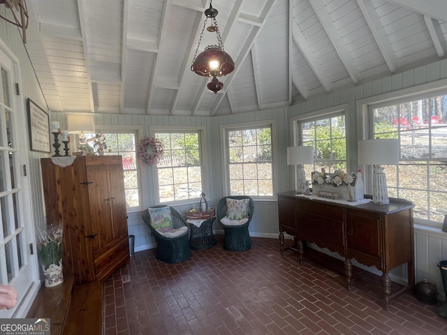 sunroom with a healthy amount of sunlight and lofted ceiling with beams