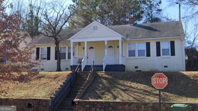 bungalow-style home with crawl space, covered porch, a chimney, and a shingled roof