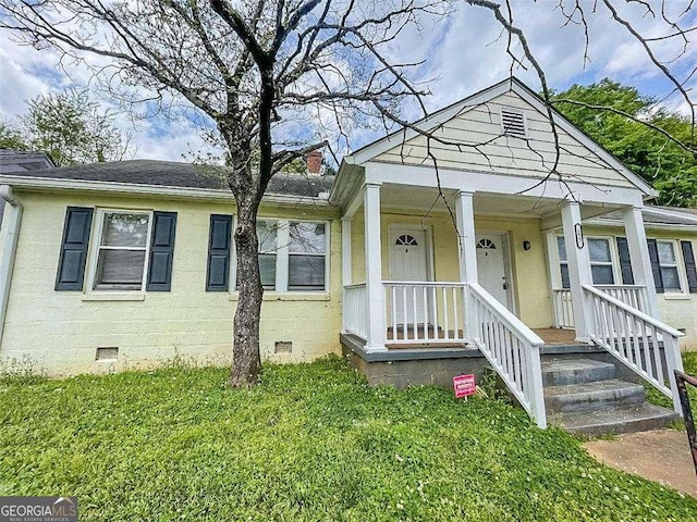 bungalow featuring crawl space, covered porch, and a front yard