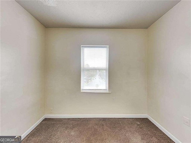 empty room with baseboards, a textured ceiling, and carpet flooring