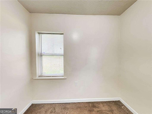 unfurnished room featuring carpet flooring, a textured ceiling, and baseboards