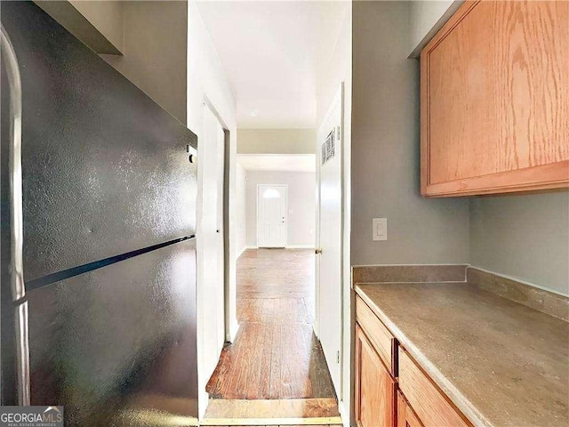 kitchen with wood finished floors and freestanding refrigerator