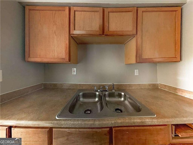 kitchen with dark countertops, brown cabinets, and a sink