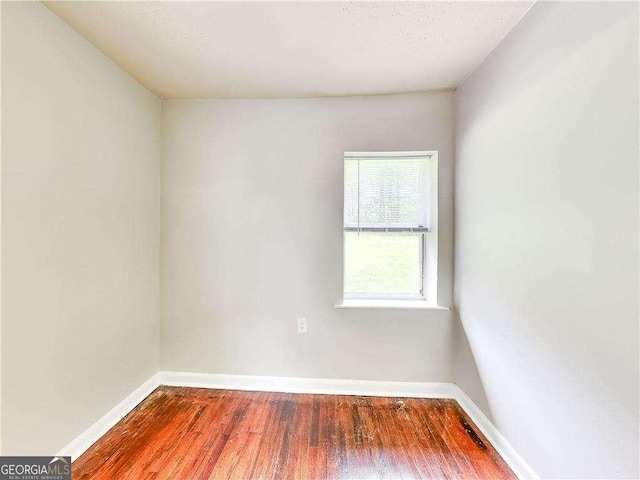 empty room featuring baseboards and wood finished floors