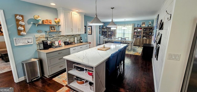 kitchen featuring backsplash, pendant lighting, dark wood-type flooring, and open shelves