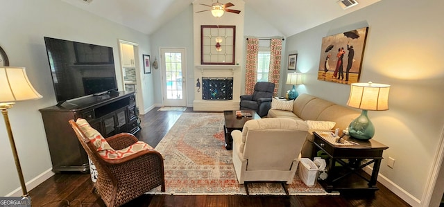 living room with visible vents, a fireplace with raised hearth, a ceiling fan, and wood finished floors