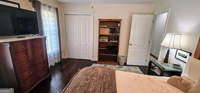 bedroom featuring dark wood-style floors, a closet, and baseboards