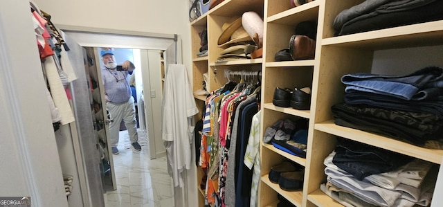 walk in closet with marble finish floor