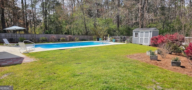 view of swimming pool with an outbuilding, a fenced in pool, a fenced backyard, a storage shed, and a lawn