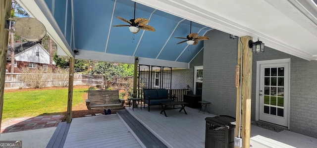 wooden terrace featuring a ceiling fan, fence, an outdoor living space, a lawn, and a grill