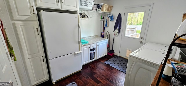 laundry area with dark wood finished floors, cabinet space, and washing machine and clothes dryer