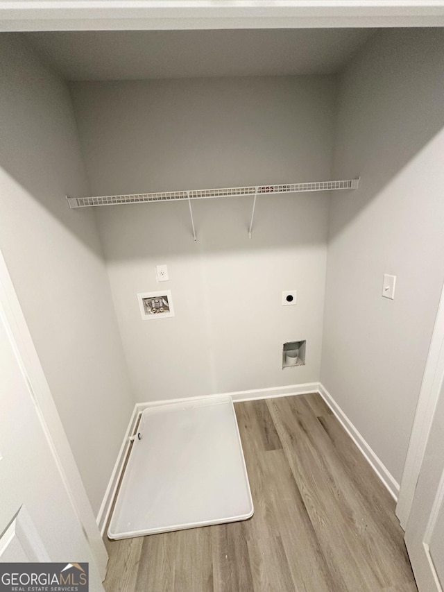 clothes washing area with baseboards, washer hookup, laundry area, wood finished floors, and hookup for an electric dryer