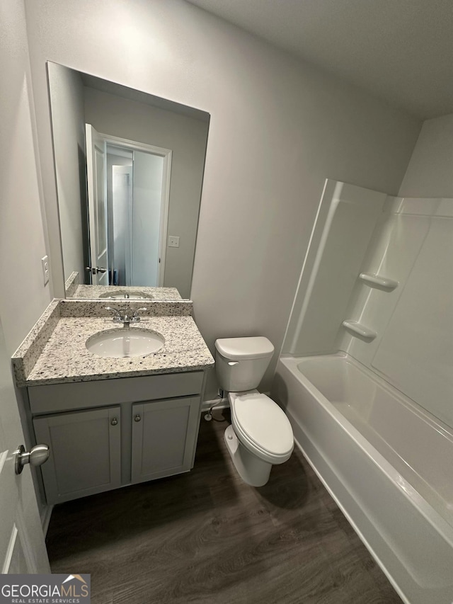 full bathroom with toilet, shower / washtub combination, wood finished floors, and vanity