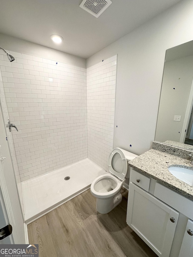 bathroom featuring visible vents, a stall shower, vanity, and wood finished floors