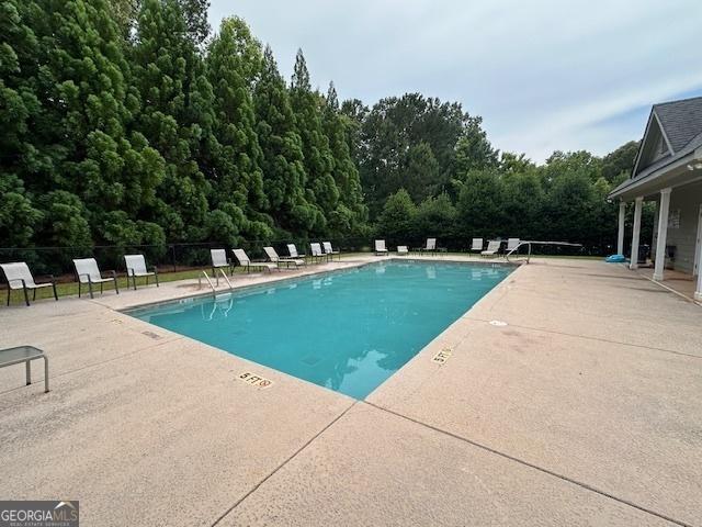 community pool featuring a patio area and fence