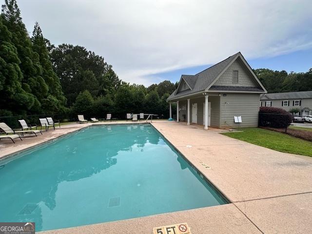 pool featuring a patio and an outdoor structure