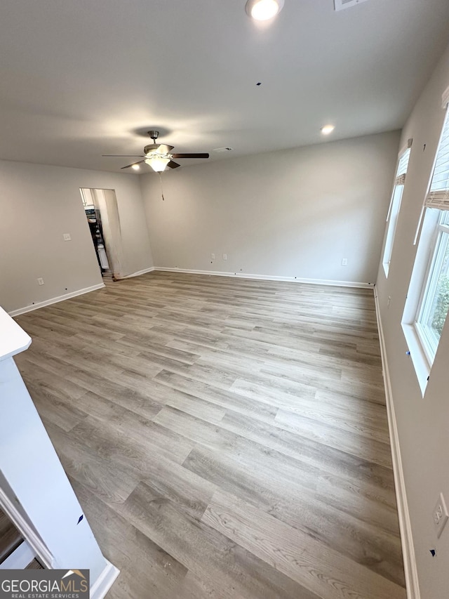 unfurnished living room featuring light wood finished floors, recessed lighting, baseboards, and a ceiling fan