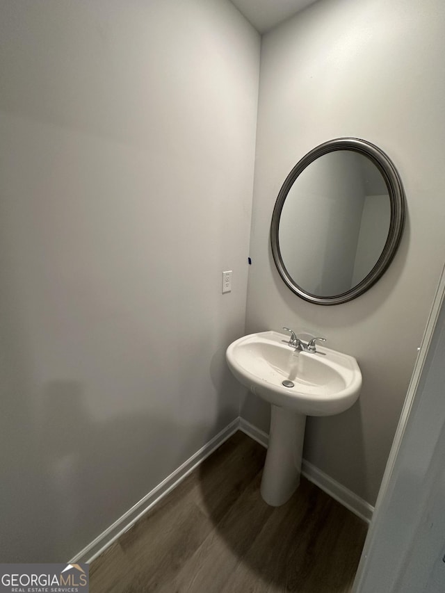 bathroom with a sink, baseboards, and wood finished floors