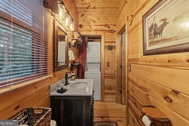 bathroom featuring wood ceiling, wooden walls, vanity, and stacked washer and dryer