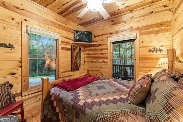 bedroom featuring a ceiling fan, access to exterior, wood ceiling, and wood walls