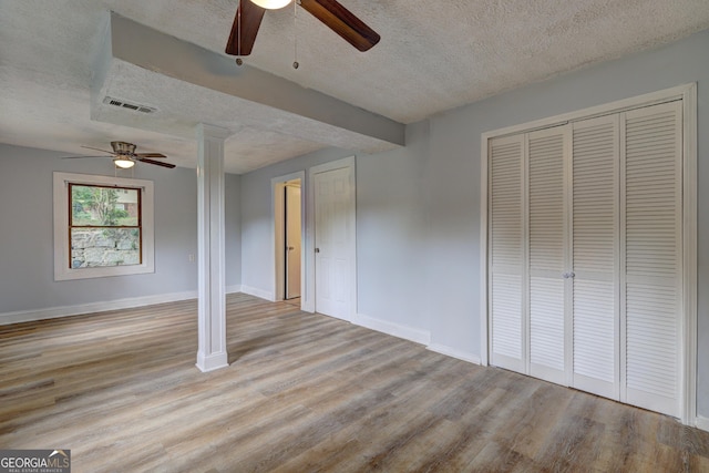 unfurnished bedroom with baseboards, a textured ceiling, visible vents, and light wood-type flooring