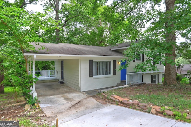 split level home featuring brick siding, concrete driveway, and a carport