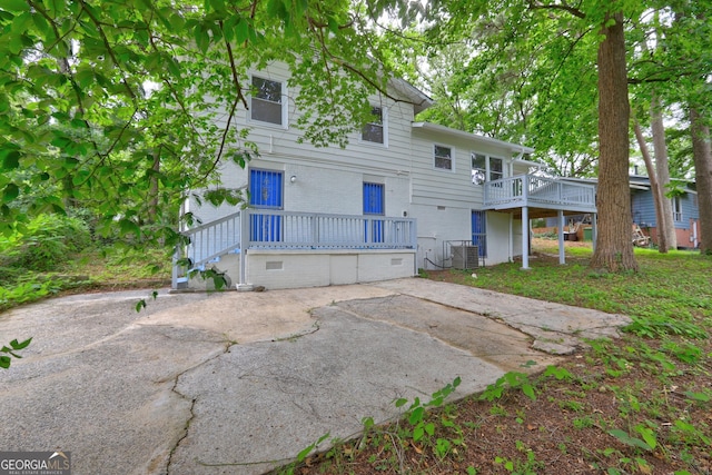 back of house with brick siding and central AC unit