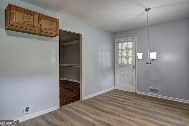 foyer featuring light wood finished floors, baseboards, visible vents, and a notable chandelier