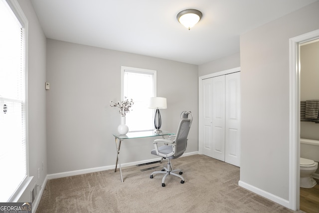 office space featuring carpet flooring, visible vents, and baseboards