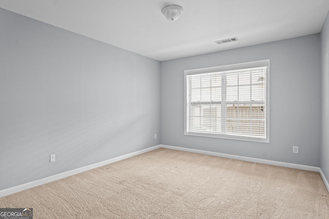 carpeted empty room featuring visible vents and baseboards