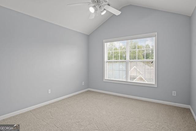 carpeted spare room with baseboards, a ceiling fan, and vaulted ceiling