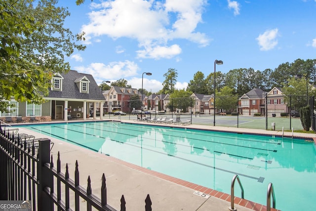 pool with a residential view, a patio, and fence