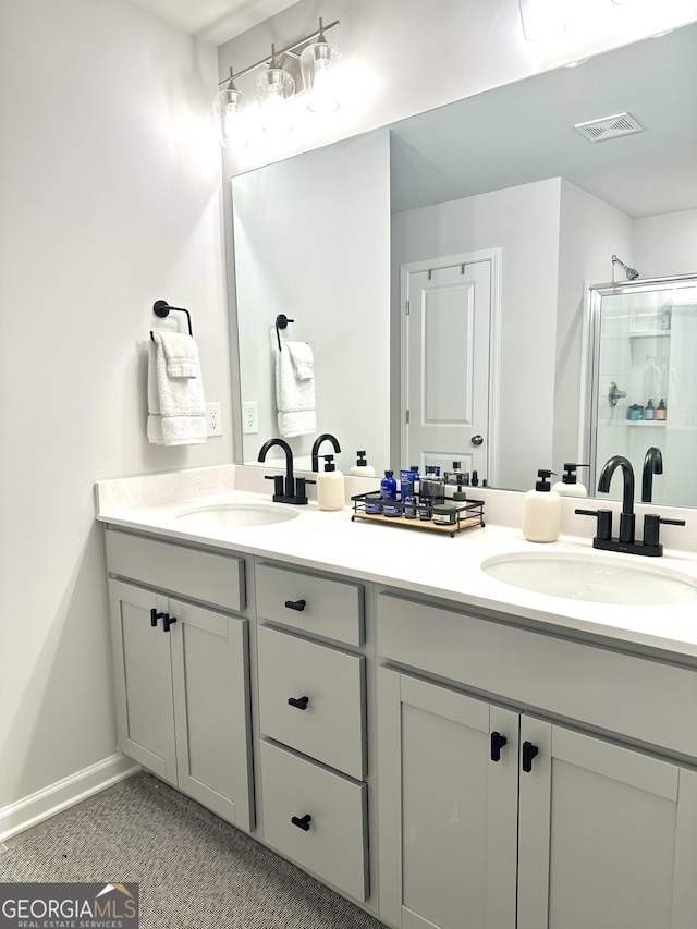 full bath featuring a sink, visible vents, double vanity, and a shower stall