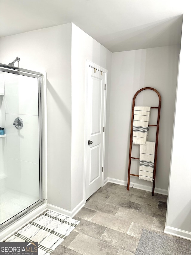 bathroom with a stall shower and baseboards