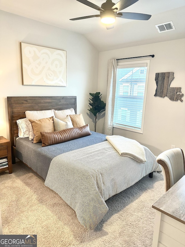 carpeted bedroom featuring visible vents, a ceiling fan, and vaulted ceiling