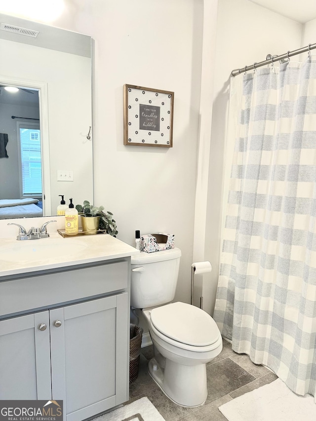 ensuite bathroom featuring visible vents, toilet, ensuite bathroom, curtained shower, and vanity