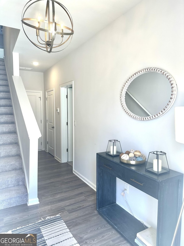 entrance foyer with an inviting chandelier, stairs, baseboards, and wood finished floors