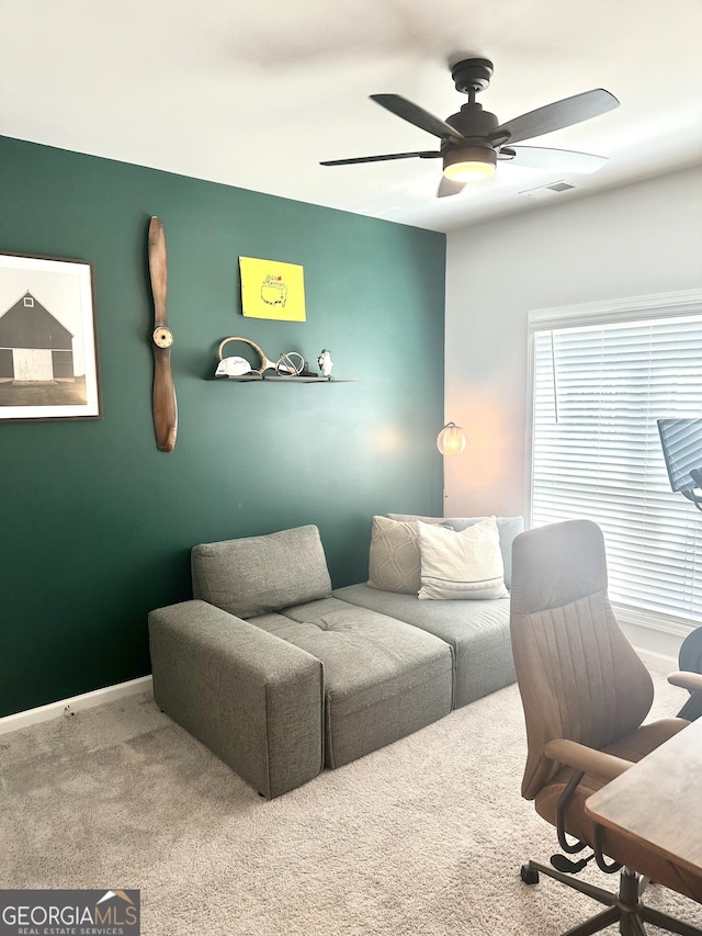 carpeted home office with a ceiling fan, visible vents, and baseboards