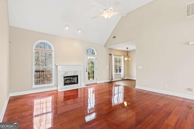 4838 Netherlands Pl, Flowery Branch, GA 30542 - unfurnished living room with a chandelier, ceiling fan, wood finished floors, a premium fireplace, and high vaulted ceiling