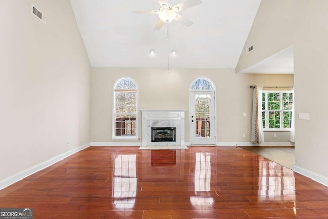 4838 Netherlands Pl, Flowery Branch, GA 30542 - unfurnished living room with wood finished floors, ceiling fan, plenty of natural light, a fireplace, and high vaulted ceiling