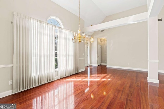 4838 Netherlands Pl, Flowery Branch, GA 30542 - unfurnished dining area with a chandelier, wood finished floors, vaulted ceiling, and decorative columns