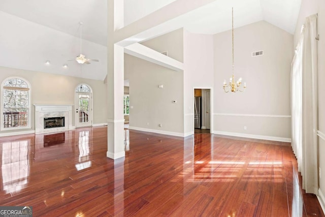 4838 Netherlands Pl, Flowery Branch, GA 30542 - unfurnished living room with wood finished floors, a chandelier, high vaulted ceiling, a premium fireplace, and ceiling fan